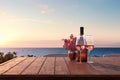 Close up of couple wine champagne glasses and bottle for celebration on wooden table with sea view and sunset sky background, Royalty Free Stock Photo