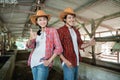 close up of a cowboy couple standing and smiling with their thumbs up