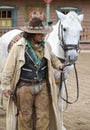 Close up of a Cowboy standing next to his horse