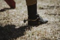 Close up on cowboys boot on the grass