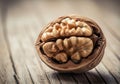 Close up of a cracked walnut revealing its intricate kernel on a rustic wooden surface Royalty Free Stock Photo