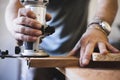 Close-up of craftsman hands working wood with a router Royalty Free Stock Photo