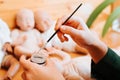 Close-up of craftsman's female hands holding bottle of silicone gel and painting brush in workshop.