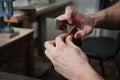 Close-up of a craftsman`s hands and the process of hand-stitching a leather wallet. Royalty Free Stock Photo