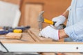 Close-up of Craftsman using hammer hobnailed in workshop, Carpenter using the hammer hit a nail for assembly wood in a carpentry