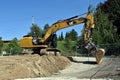 Close-up of a crawler excavator with scoop loader working on the construction site.