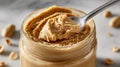 Close-up of creamy peanut butter in a jar with spoon on marble. Royalty Free Stock Photo