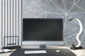 Close up of creative designer desk top with empty black computer monitor, various items and light concrete wall. Mock up