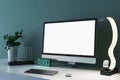 Close up of creative designer desk top with empty white mock up computer monitor, supplies and various items on blue concrete wall