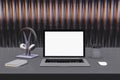 Close up of creative designer desktop with blank white laptop screen with headset, pencils and other items. Metal bars background