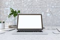 Close up of creative designer desktop with blank white laptop screen, lamp, supplies various other objects and shiny light tile Royalty Free Stock Photo