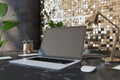 Close up of creative designer desktop with empty laptop screen, lamp, supplies various other objects and shiny golden tile wall