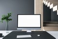 Close up of creative designer desktop with empty white computer monitor frame, decorative items and modern interior in the Royalty Free Stock Photo