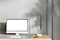 Close up of creative designer desktop with empty white computer screen, keyboard and other items on concrete wall background. Royalty Free Stock Photo