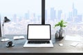 Close up of creative designer desktop with empty white laptop, lamp, coffee cup and panoramic city view in the background. Mock up Royalty Free Stock Photo