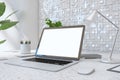 Close up of creative designer desktop with empty white laptop screen, lamp, supplies various other objects and shiny light tile