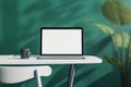 Close up of creative designer office desktop with empty white laptop screen with mock up place in frame, green wall background Royalty Free Stock Photo