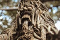 Close up creepy balinese statue on pedestal. Stone figure of the God in the garden.