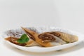 Close-up crepe with bananas and chocolate on white plate Royalty Free Stock Photo