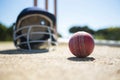 Close up of cricket ball with helmet on pitch Royalty Free Stock Photo