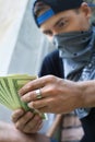 Close up of criminal man holding money.