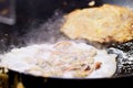 Close-up of Crispy Fried Mussel Pancake or Mussel Omellette on hot pan, thai street food market Royalty Free Stock Photo