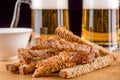 Close-up of crispy garlic croutons against a background of glass mugs of beer. Royalty Free Stock Photo