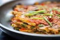 close-up of crispy kimchi pancake edge on a pan