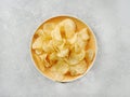 Crispy potato chips or crisps in a yellow plate