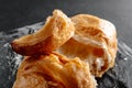 Close-up of croissants on a dark background. One croissant broken into pieces. Fresh and delicious French pastries Royalty Free Stock Photo