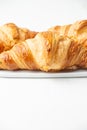 Close up of croissants on plate on table and white background, Royalty Free Stock Photo