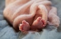 Close up crop legs of newborn baby wrapped in warm knitted blanket Royalty Free Stock Photo