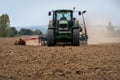 Close-up of crop with Tractor ploughing field. Royalty Free Stock Photo