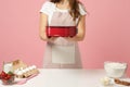 Close up cropped chef cook confectioner or baker in apron white t-shirt cooking cake or cupcake at table hold baking Royalty Free Stock Photo