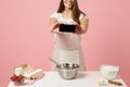 Close up cropped chef cook confectioner or baker in white t-shirt cooking cake or cupcake at table hold using mobile