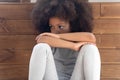 Offended little african american girl sitting on floor. Royalty Free Stock Photo