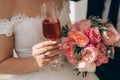 A close-up of a cropped frame of a bride in a white dress is holding in her hand a wedding bouquet of pink peonies, and Royalty Free Stock Photo