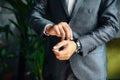 Close-up of a cropped frame of a man in a business suit buttoning his expensive watch on his hand. A businessman is Royalty Free Stock Photo