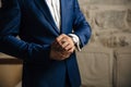 A close-up of a cropped frame of a man in an expensive classic costume looks at his watch. The businessman is in a hurry Royalty Free Stock Photo