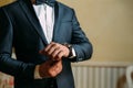 A close-up of a cropped frame of a man in an expensive classic costume looks at his watch. The businessman is in a hurry Royalty Free Stock Photo