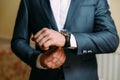 A close-up of a cropped frame of a man in an expensive classic costume looks at his watch. The businessman is in a hurry Royalty Free Stock Photo