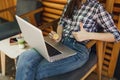 Close up cropped girl in street coffee shop cafe sitting with laptop pc computer, hold bitcoin, metal coin of golden Royalty Free Stock Photo