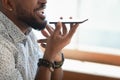 Closeup view african guy talking with friend on speakerphone