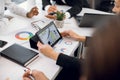 Close up cropped image of hands of diverse team of businesspeople, sitting at the table at office, and working with Royalty Free Stock Photo