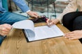 Close up cropped image of hands of two business people, man and woman, sitting at the table in modern office, signing Royalty Free Stock Photo