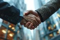 Close-up cropped image of two businessmen in classic suits shaking hands. Modern office building buildings on the Royalty Free Stock Photo