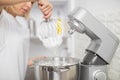 Close up cropped indoor shot of professional female chef, making desserts at her pastry shop, remowing mixer whisk with Royalty Free Stock Photo