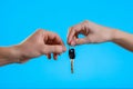 Close up cropped man woman hands present give each other gift car keys  on pastel blue background in studio Royalty Free Stock Photo