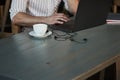 Close up cropped photo. Adult man sits in cafe at daytime and using the laptop for the remote work