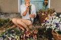 Close-up, cropped photo. A female florist sits in the country amidst a harvest of dried flowers and makes a beautiful holiday